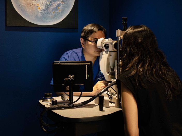 Dr Jason Lee at a slit-lamp-mounted retinal laser, treating a patient.
