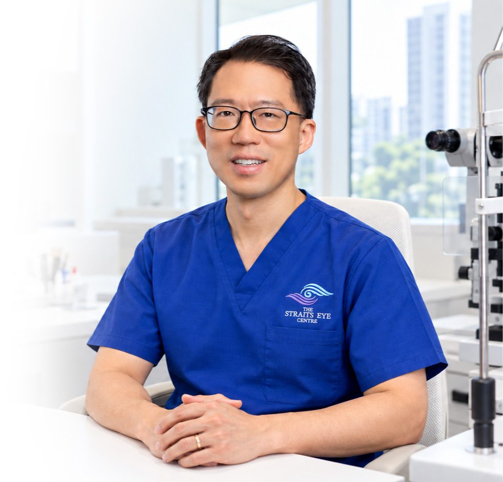 Dr Laurence Lim Shen in The Straits Eye Centre scrubs, seated at a slit lamp.