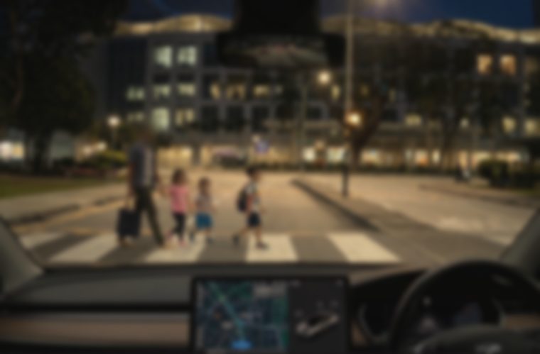 The same view, blurred and washed out, the street lights spread into haloes and the man and children barely separable from the road behind them.